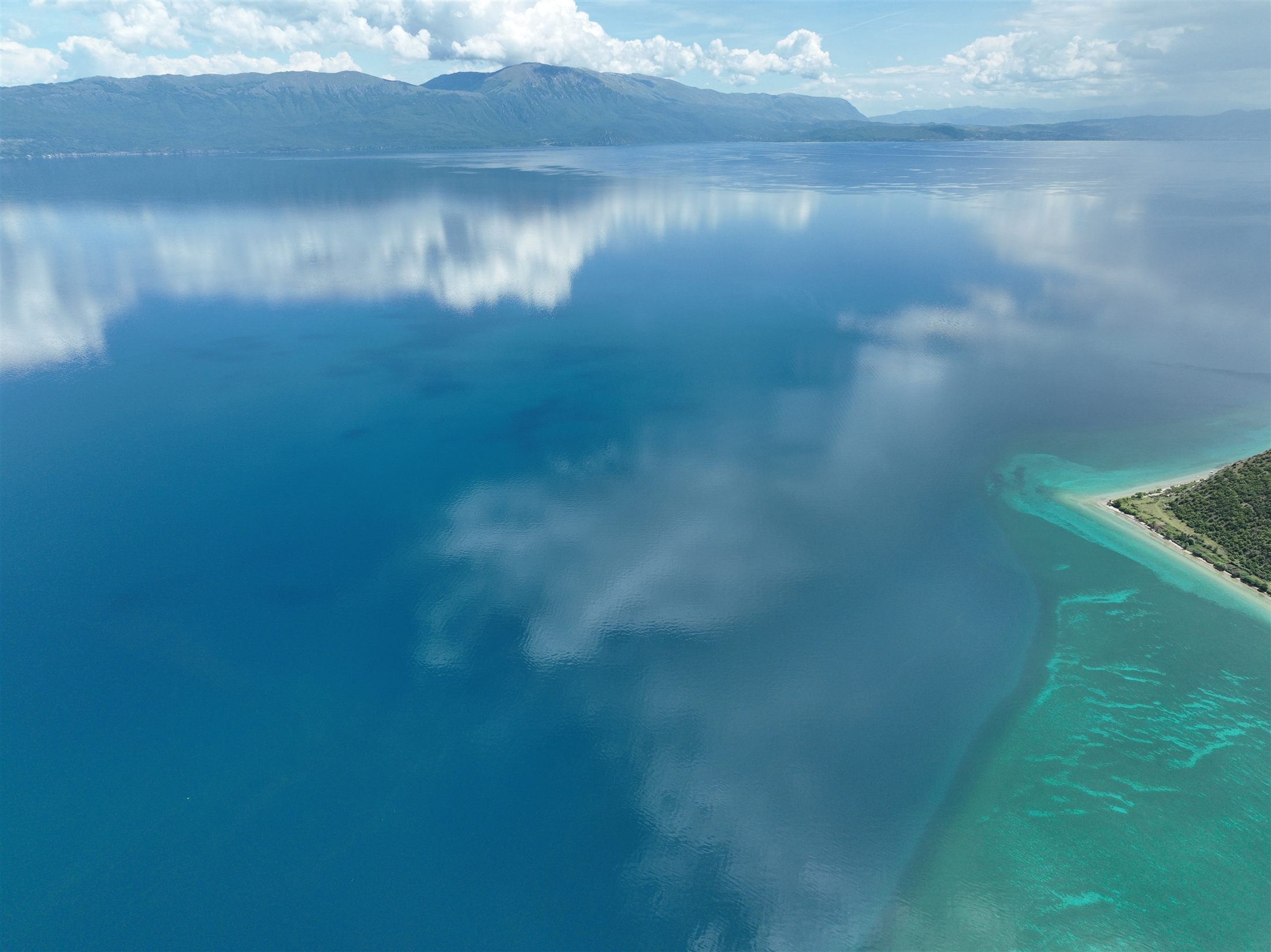 Lake Ohrid, mirror-still with clouds reflected on the surface