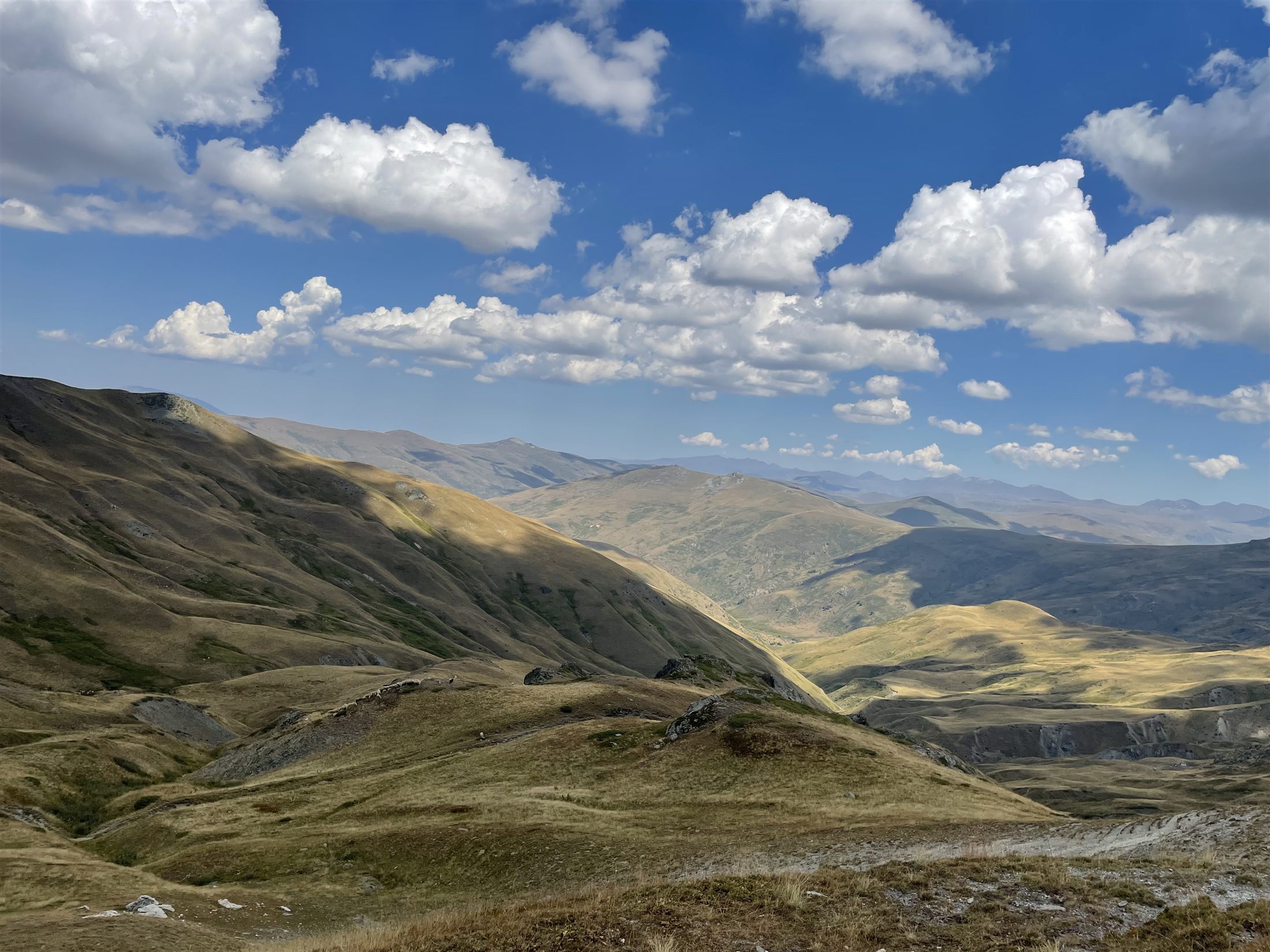 The mountain range above Radomirë under a cloudy sky